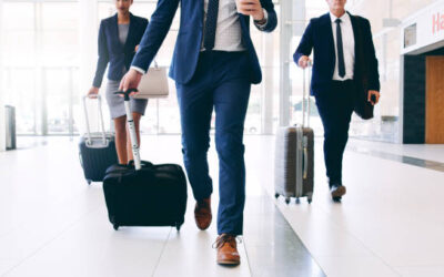 Cropped shot of three unrecognizable businesspeople walking and pulling suitcases while in the office during the day